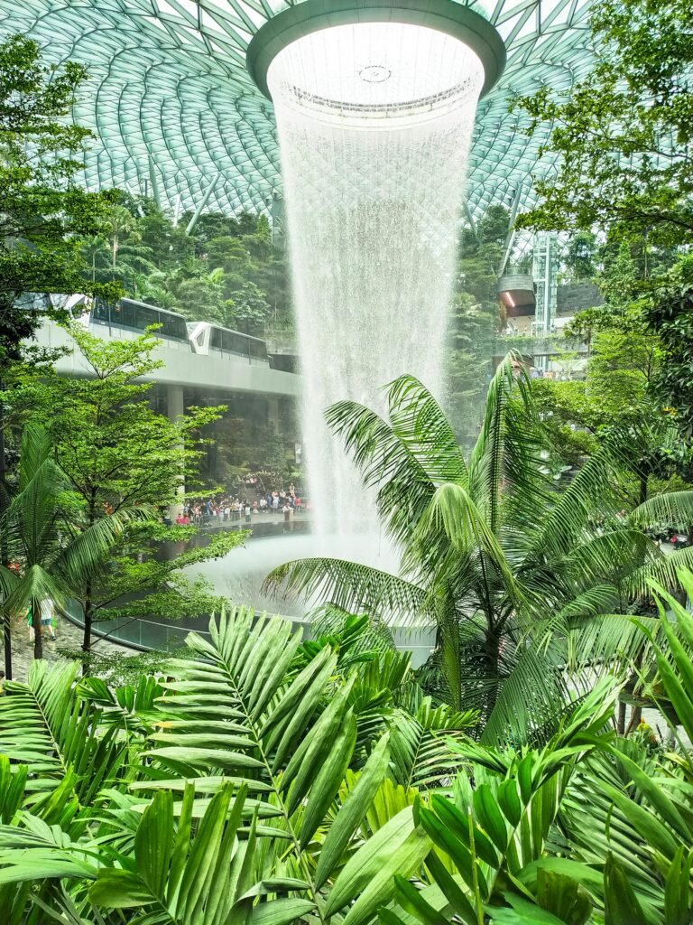 About me Explore the stunning indoor Rain Vortex waterfall surrounded by lush greenery at Jewel Changi Airport, Singapore.